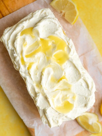A loaf cake topped with lemon curd frosting.