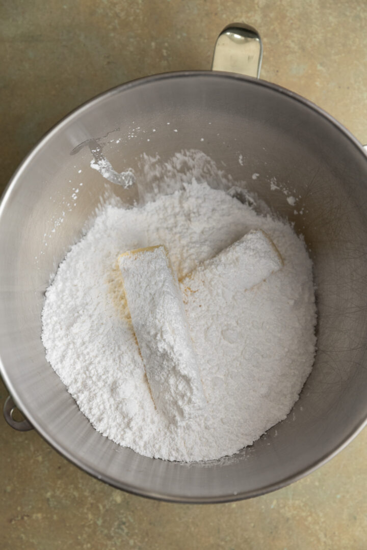 Powdered sugar and butter in a mixing bowl. 