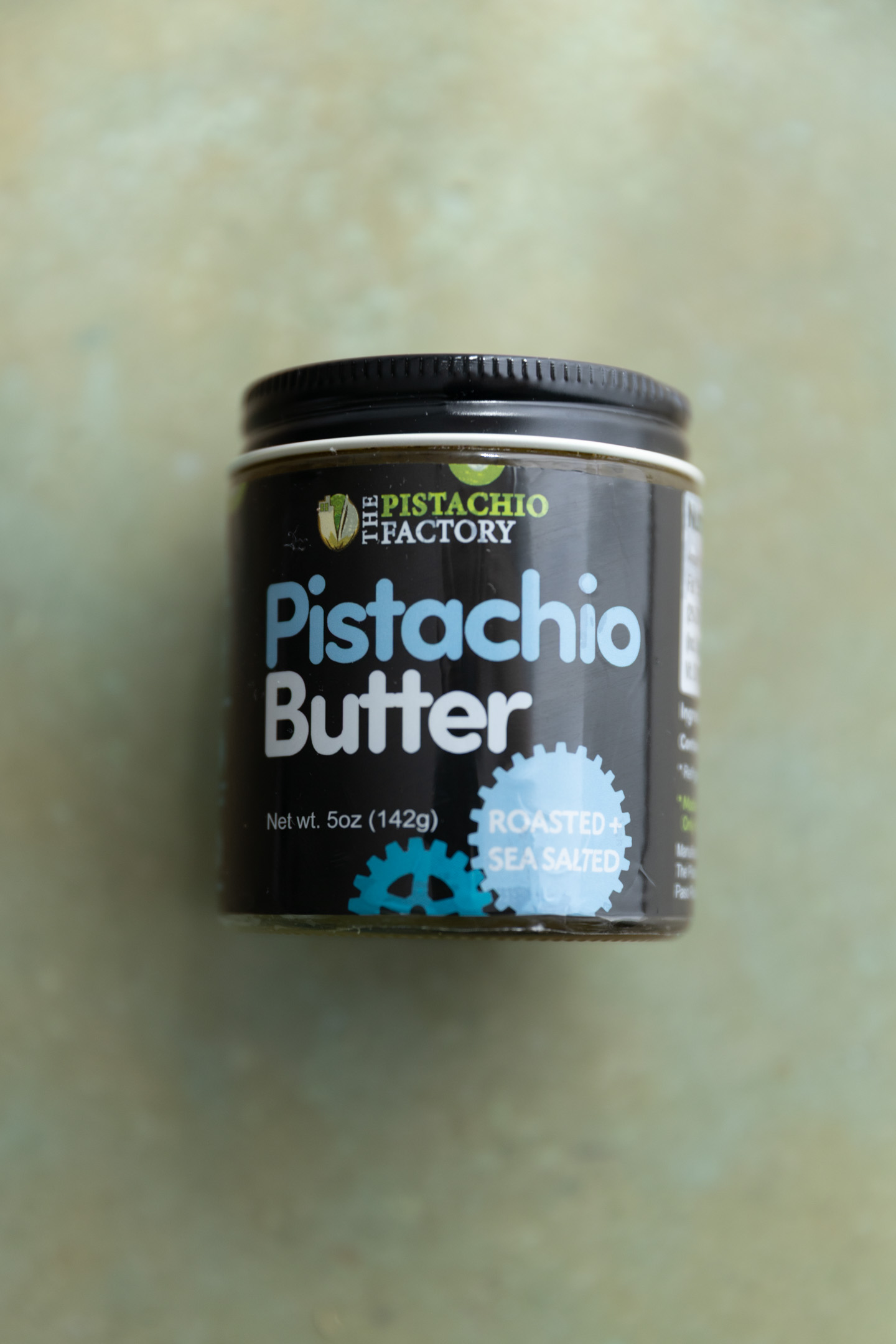 Pistachio butter on a green surface.
