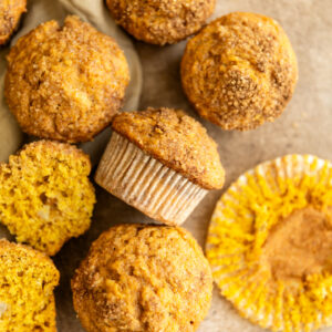 Pumpkin banana muffins on a brown surface.