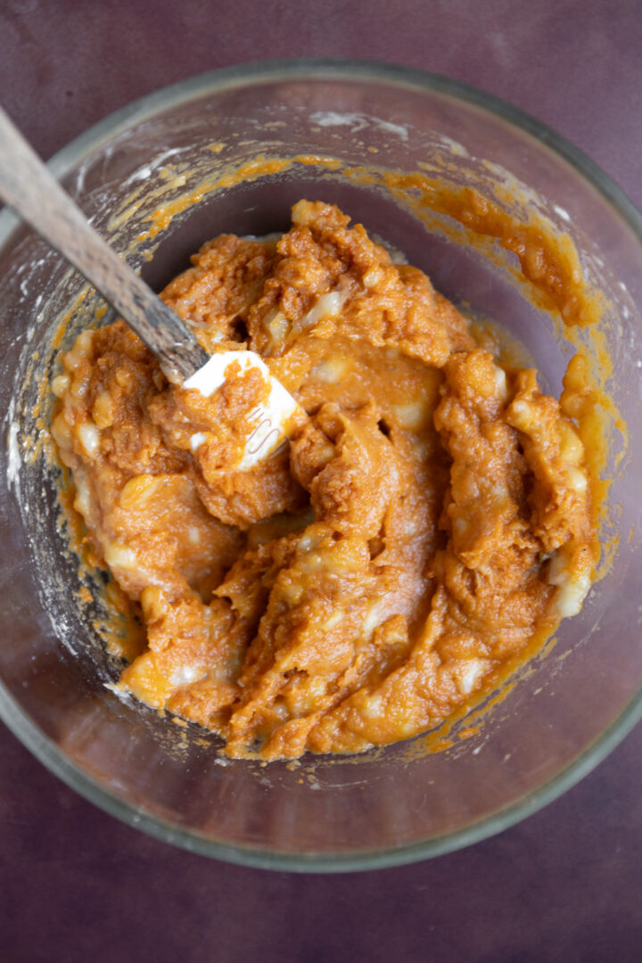 Pumpkin puree and mashed banana mixed in a bowl.