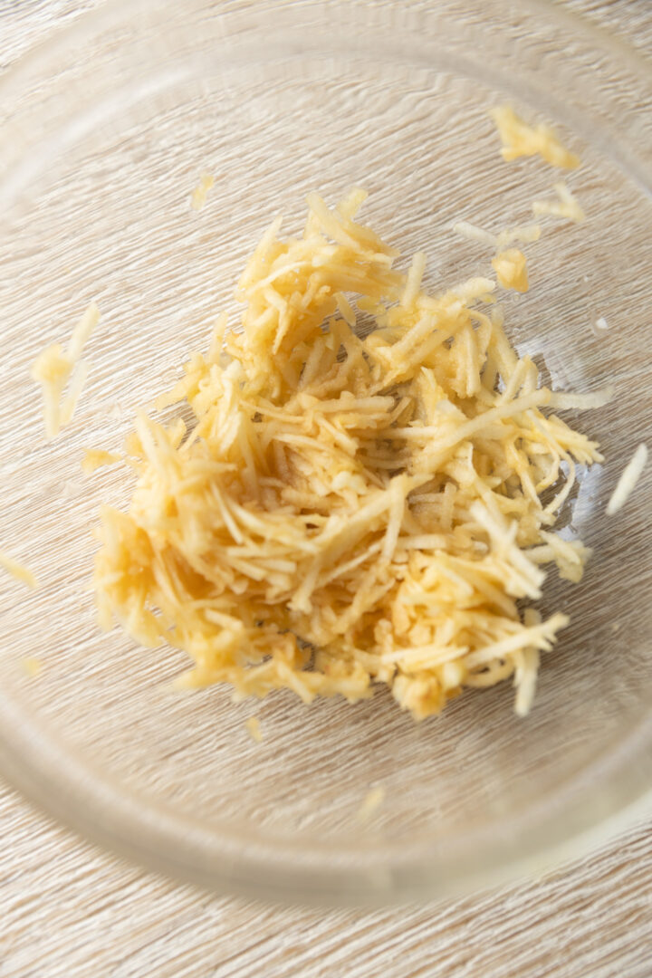 Grated apple in a glass bowl.