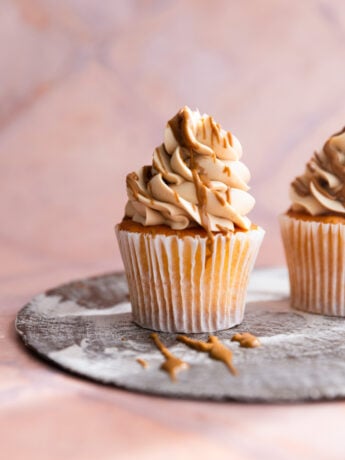 A cupcake frosted with cookie butter frosting and drizzled with melted cookie butter.