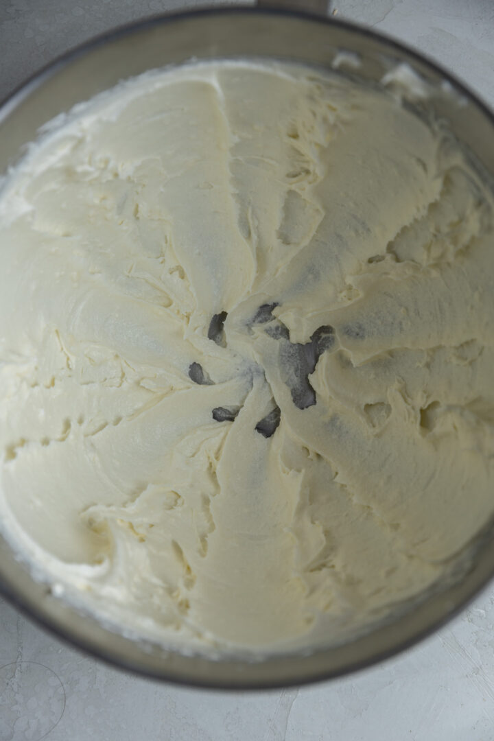 Cream cheese, butter, and sugar creamed in a bowl. 