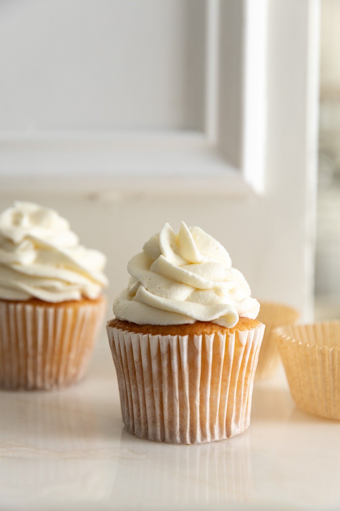 Cream cheese frosting without powdered sugar piped on a cupcake.