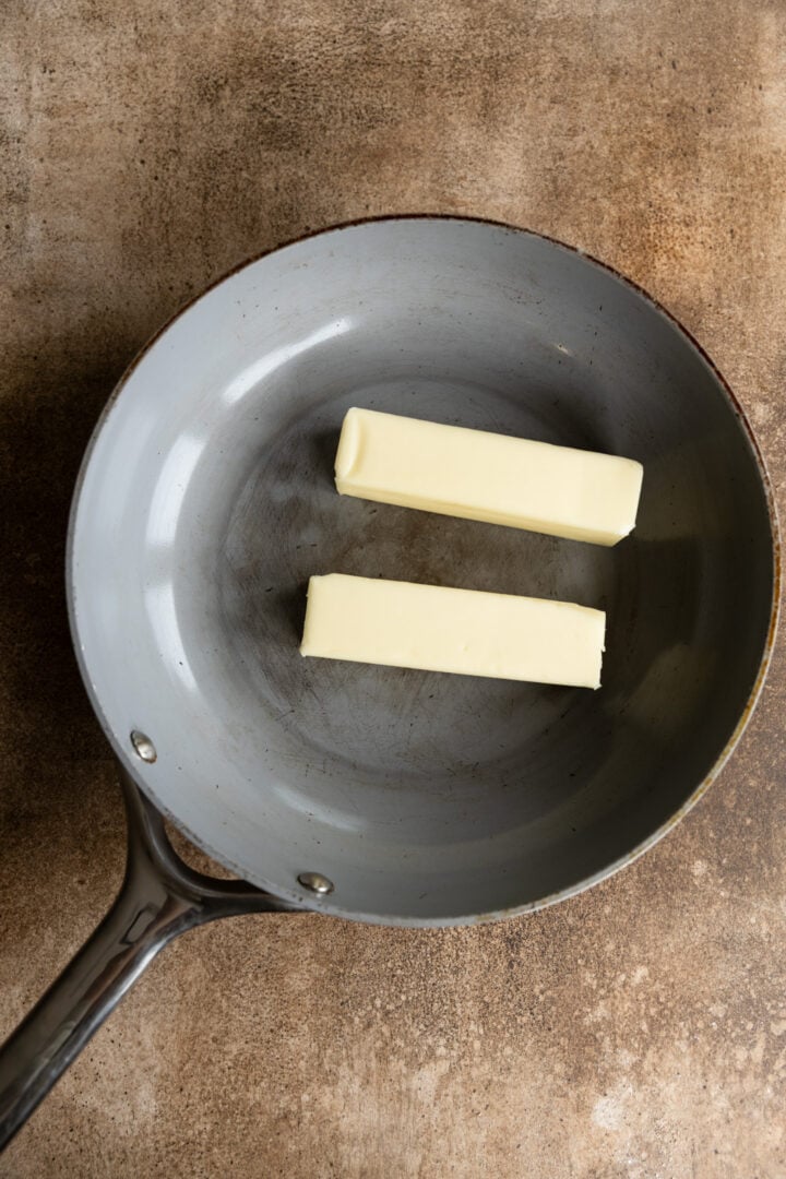 2 sticks of butter added to a skillet. 