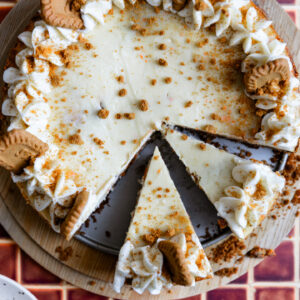 Carrot cake cheesecake with 2 slices cut out.