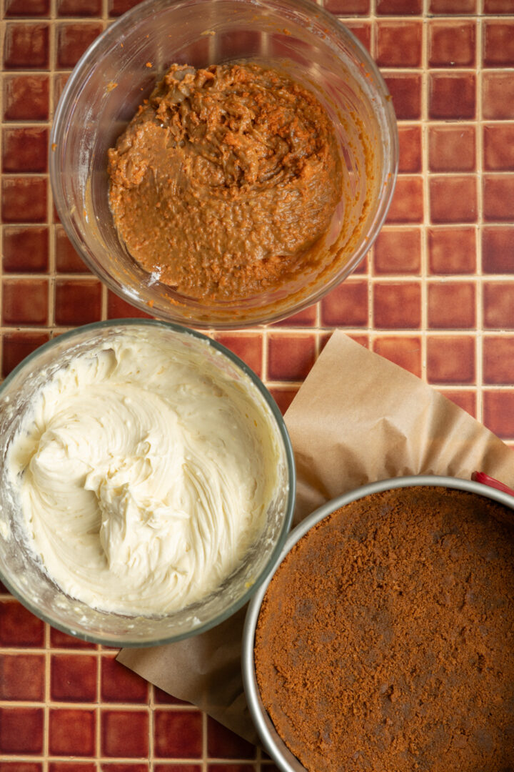 Three bowls of ingredients for a carrot cake cheesecake.