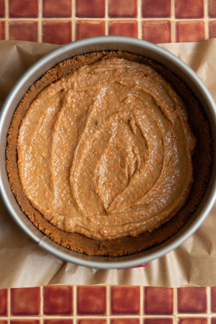 Carrot cake batter spread thin on top of the cookie crust.