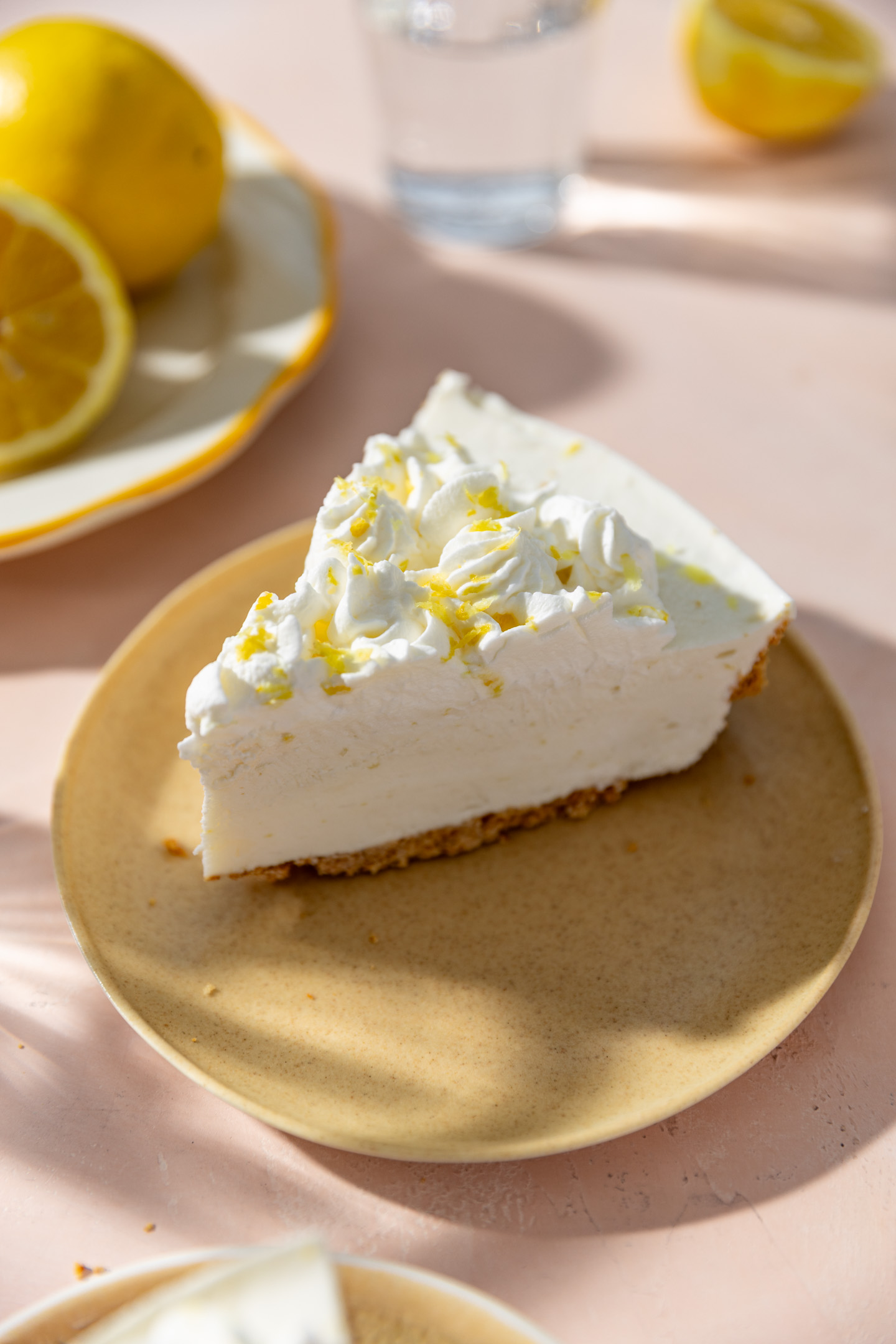 A slice of no bake lemon cheesecake on a yellow plate.