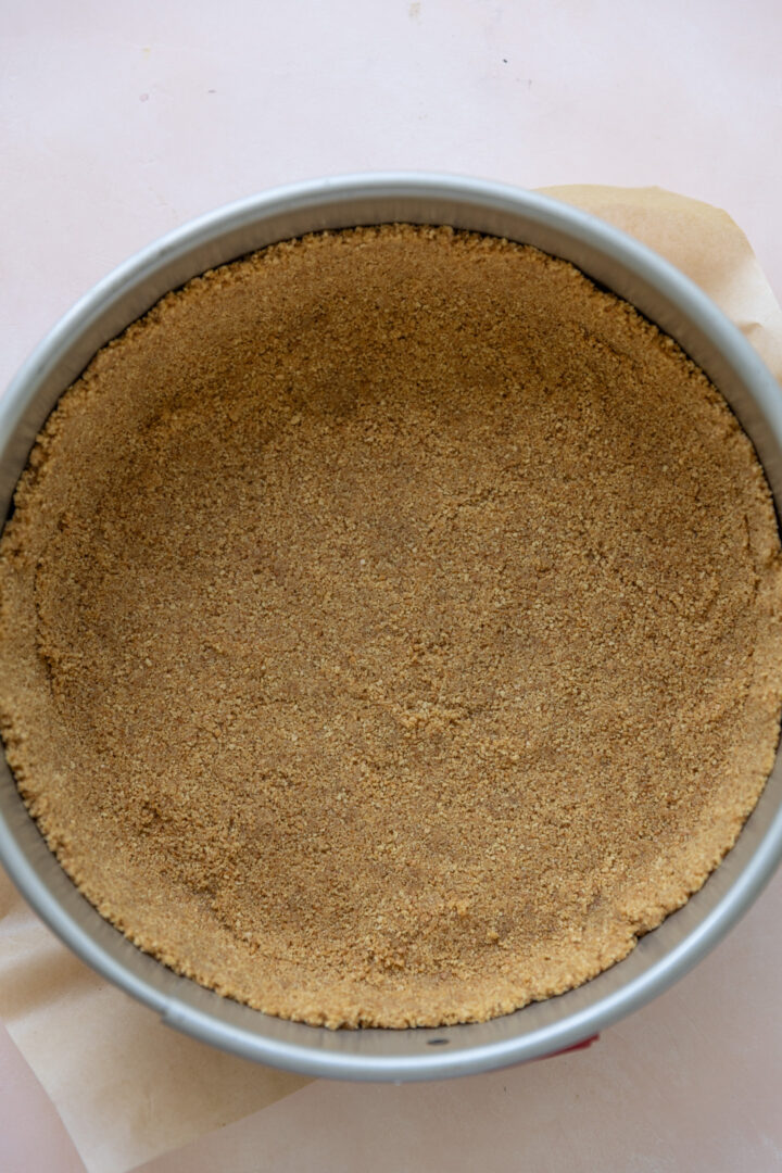 A graham cracker crust pressed into a springform pan.