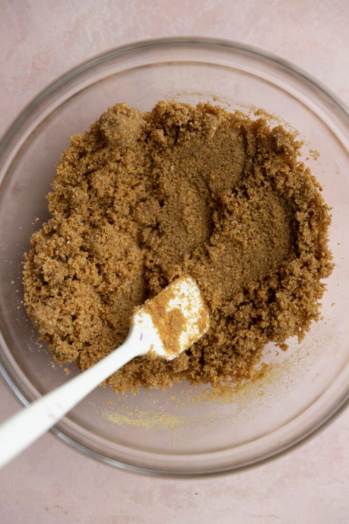 Graham cracker base mixture for a cheesecake in a bowl.