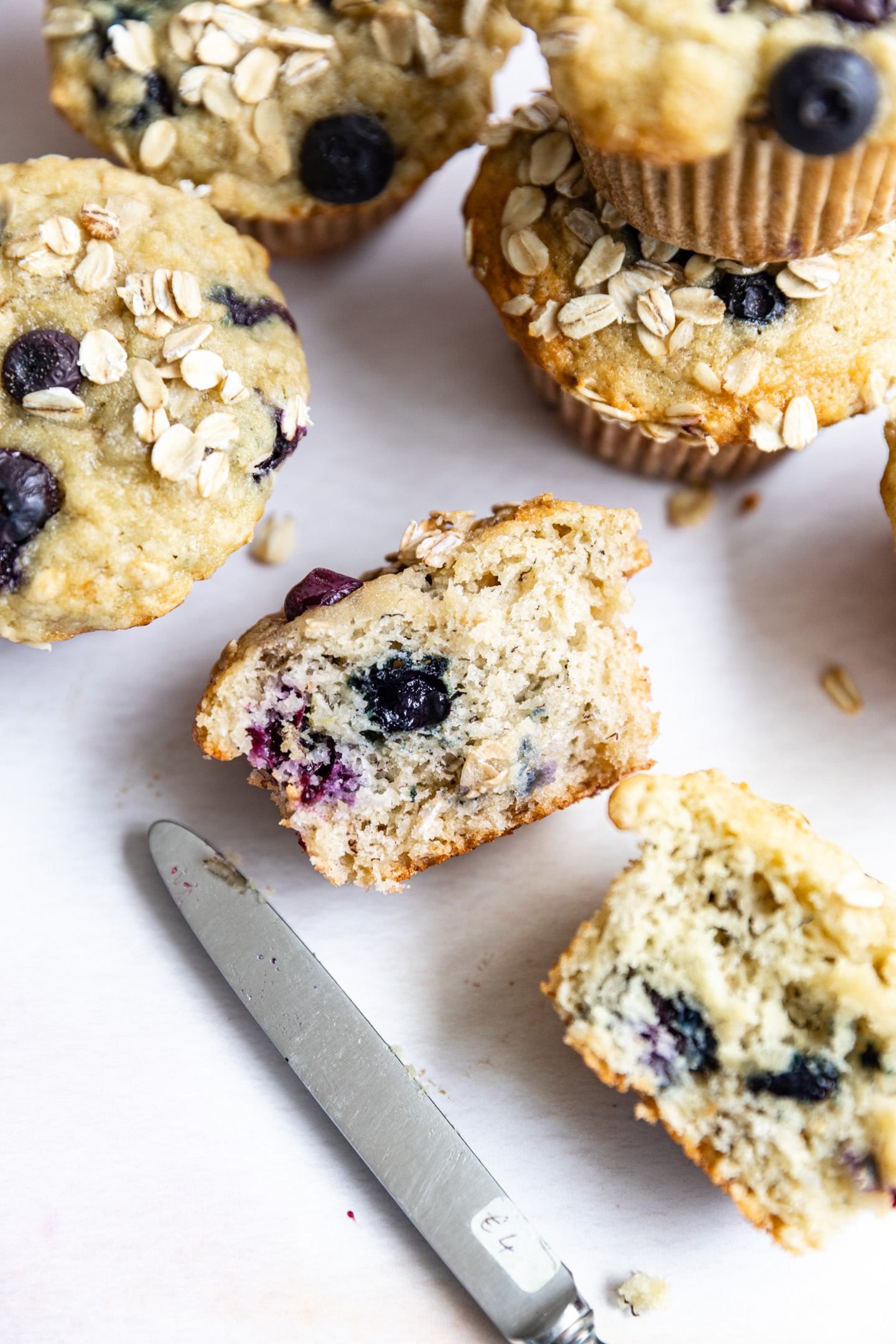 A banana blueberry oat muffin cut in half to show the inside.