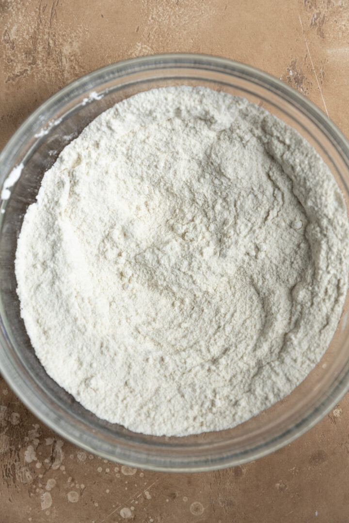 Dry ingredients for apple muffins in a glass bowl.