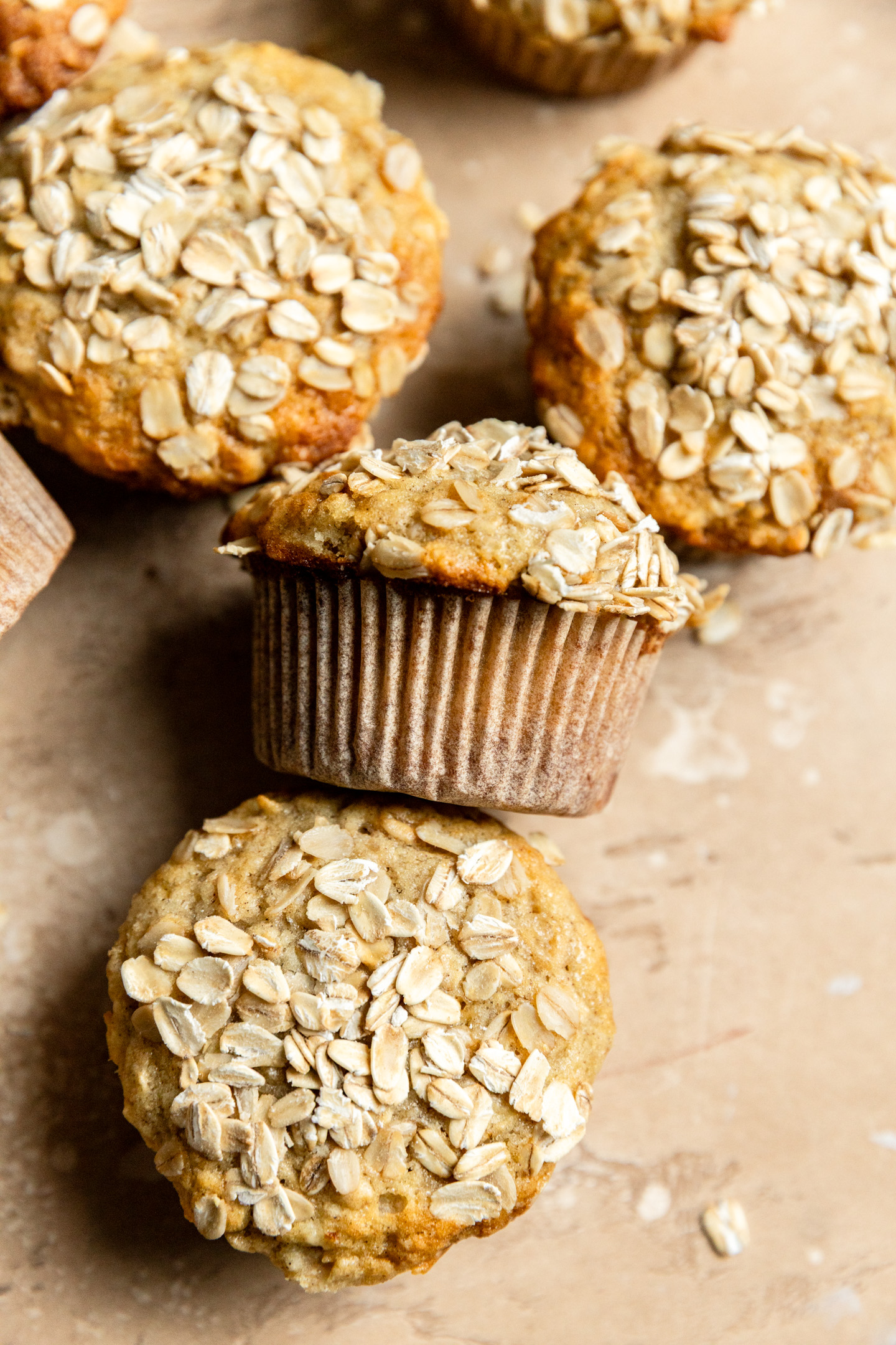 Apple oat muffins on a beige surface.