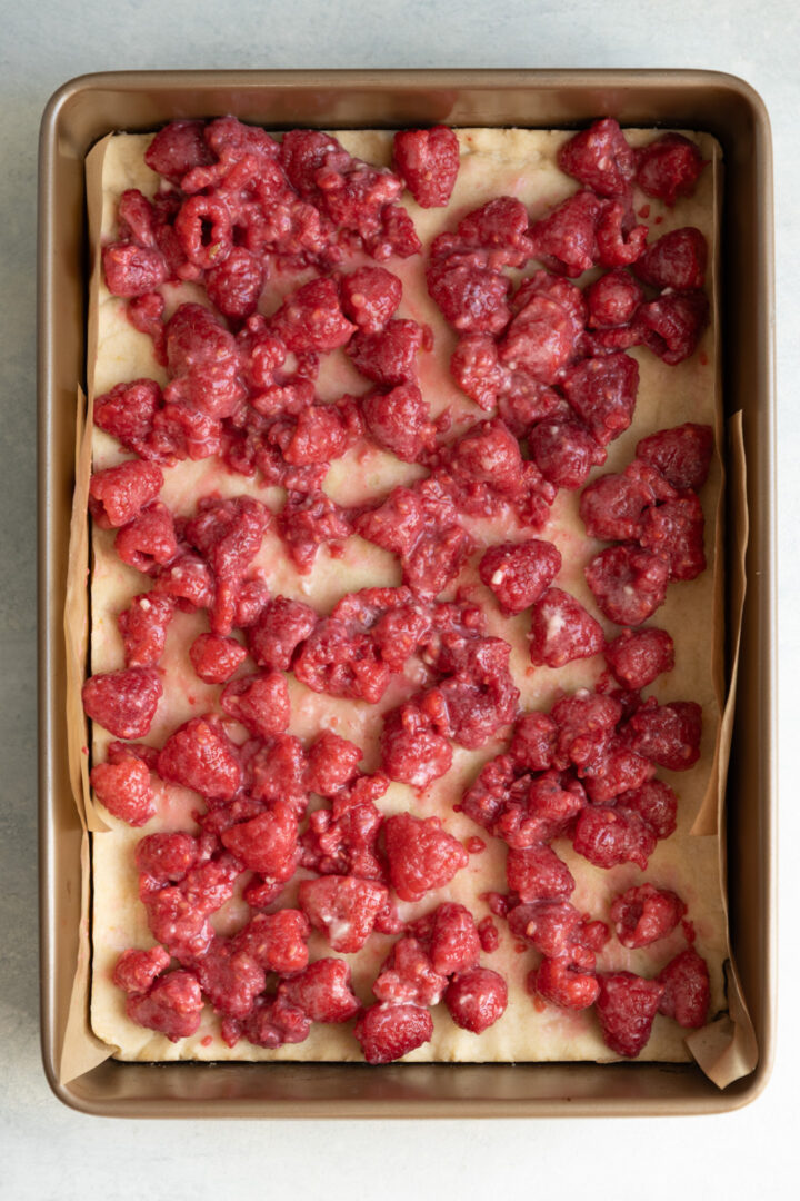 Raspberry filling spread on top of lemon shortbread.