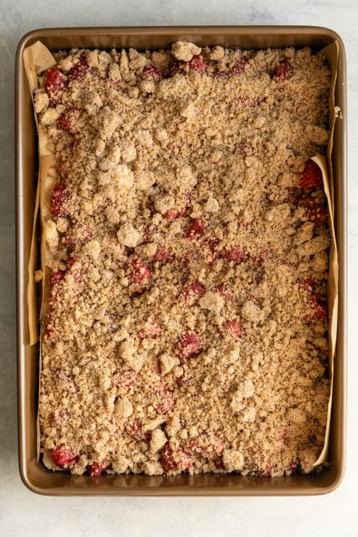 Lemon raspberry crumb bars pre baked in a 9x13 inch dish.