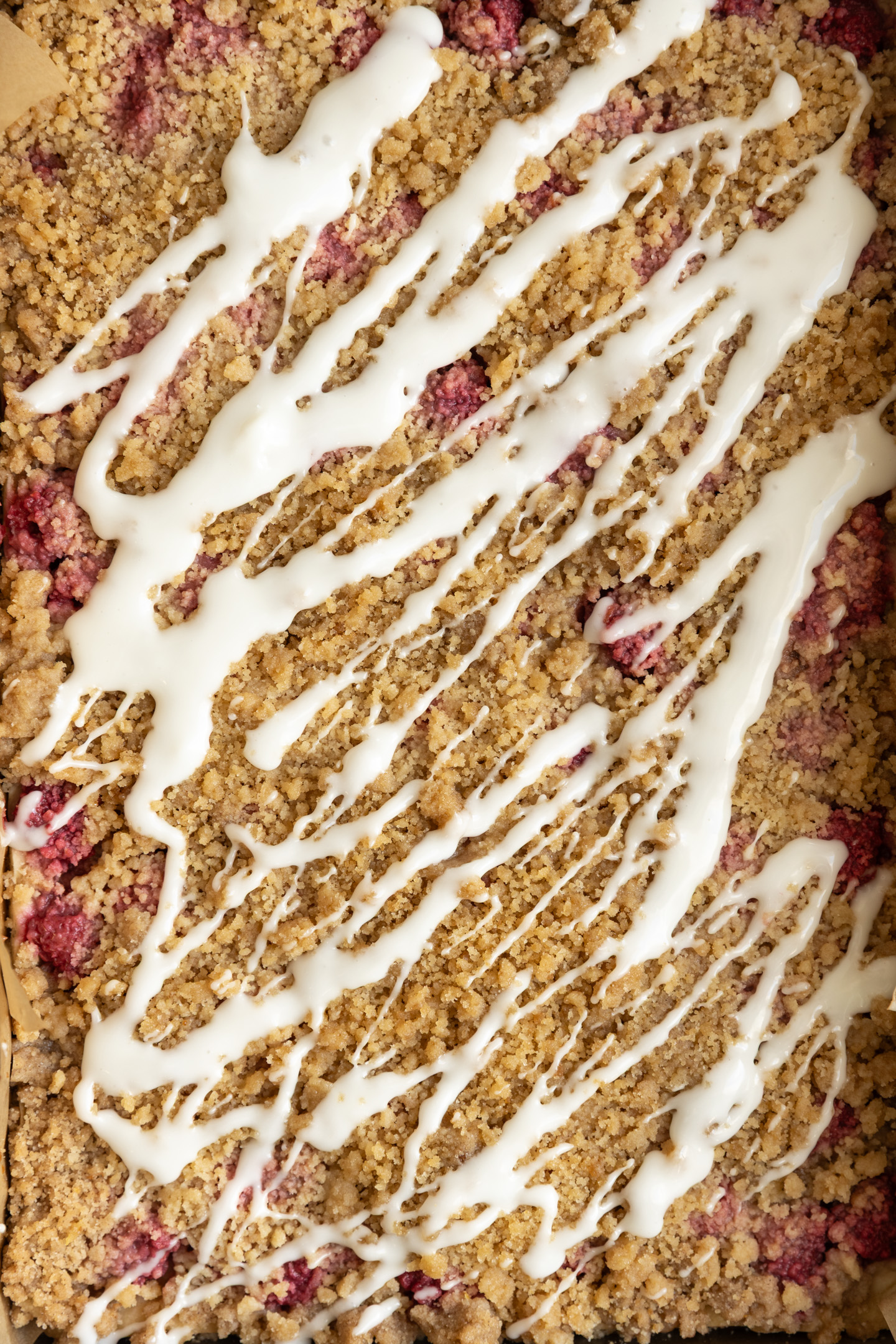 Raspberry lemon crumble bars drizzled with a white glaze.