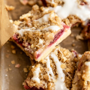 A lemon raspberry crumb bar cut into a square and leaning on its side.