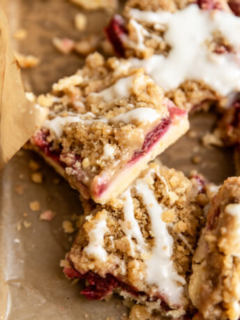 A lemon raspberry crumb bar cut into a square and leaning on its side.