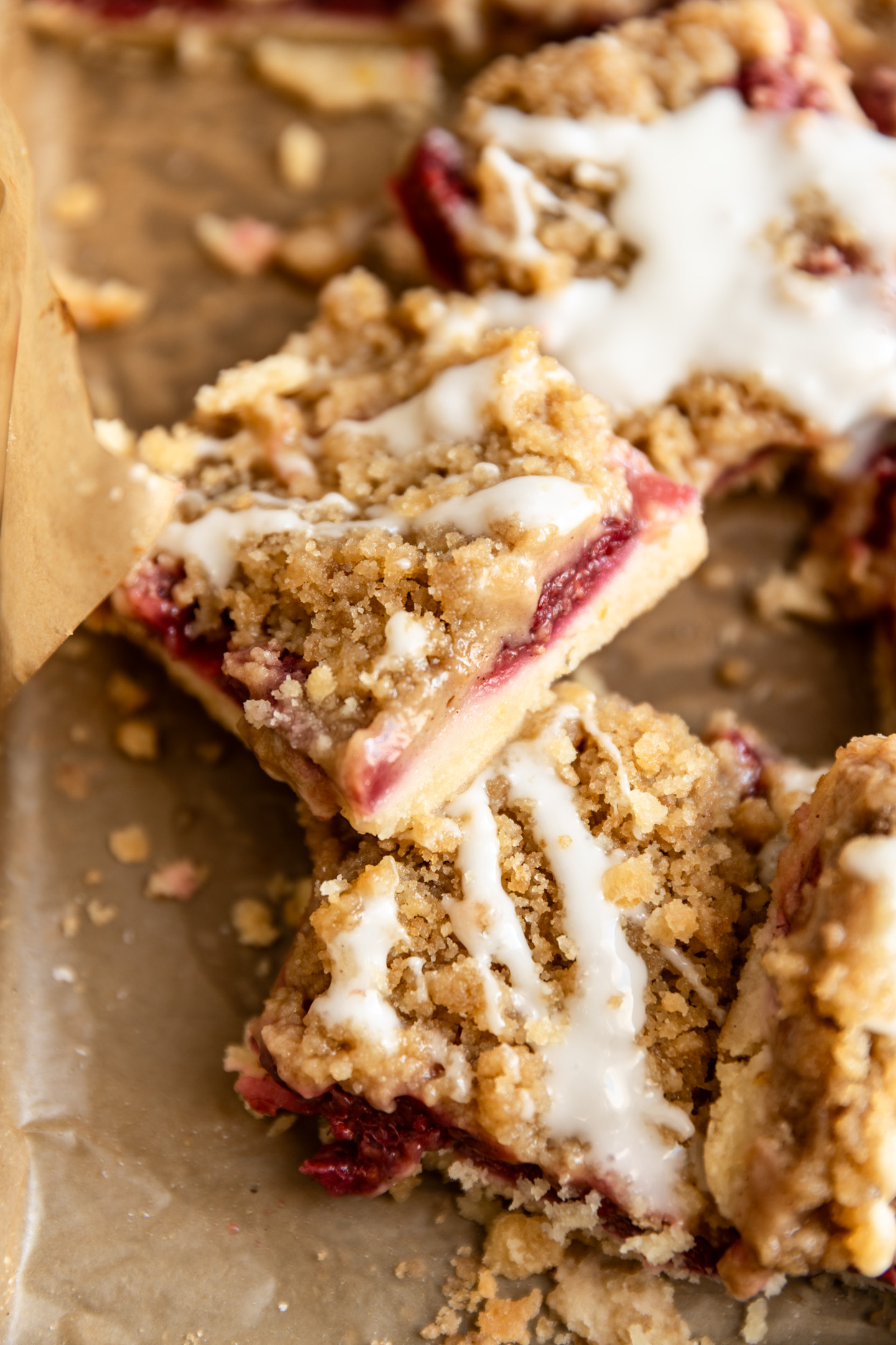 A lemon raspberry crumb bar cut into a square and leaning on its side.