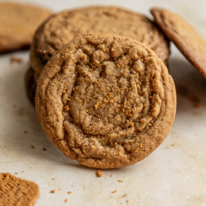 A cookie butter cookie leaning against a stack of cookies.